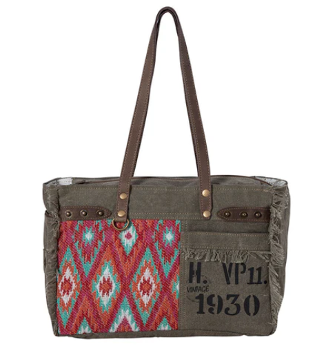 MYRA-High Trails crossbody bag with vintage overprint, textured gray sandstone canvas, colorful rug design, and leather accents.