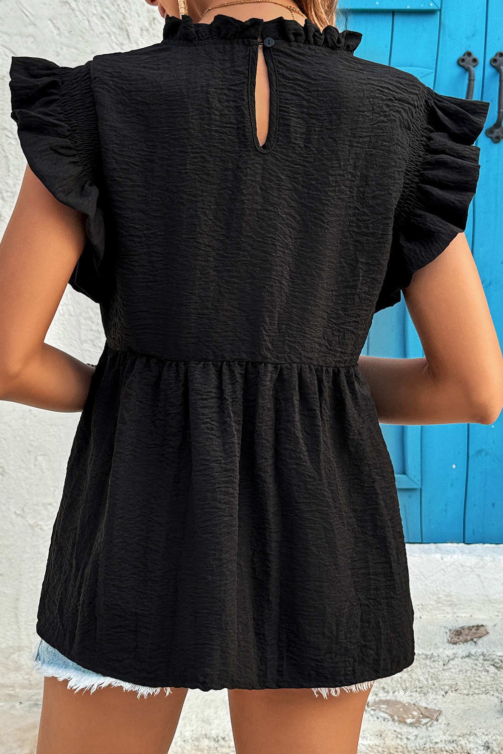 Black ruffled textured blouse - lifestyle front on model with straw hat showing full summer styling