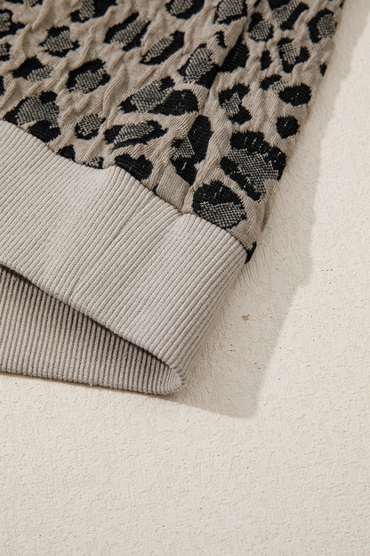 Beige leopard jacquard knit zip collar top - angled view on model showing cap sleeve and ribbed hem