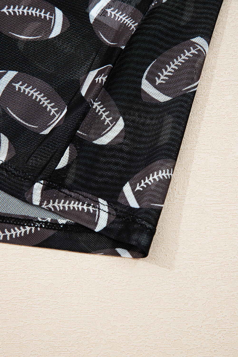 Close-up of sheer mesh fabric and football print