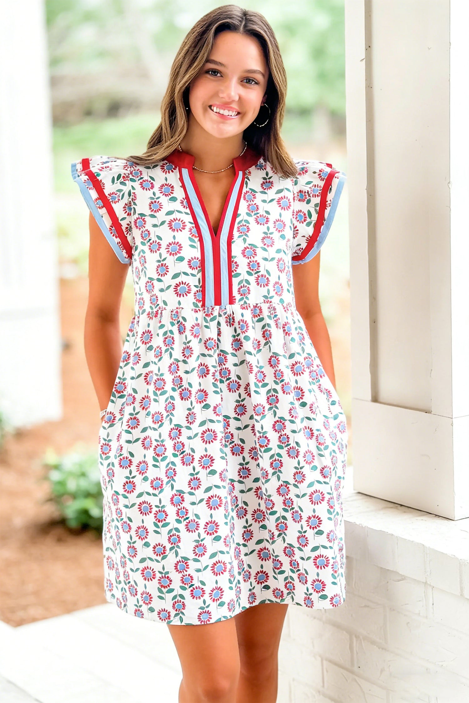 Red floral contrast trim flutter sleeve mini dress - close-up front on model showing pockets and smocked empire waist