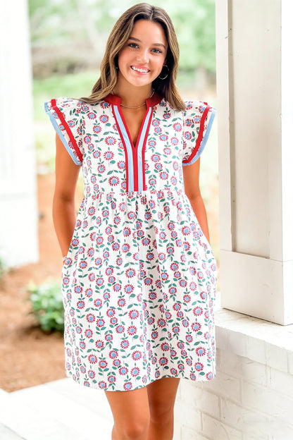 Red floral contrast trim flutter sleeve mini dress - close-up front on model showing pockets and smocked empire waist