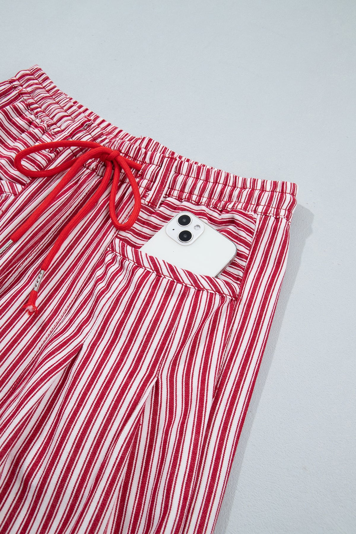 Front view of red-and-white striped drawstring pants