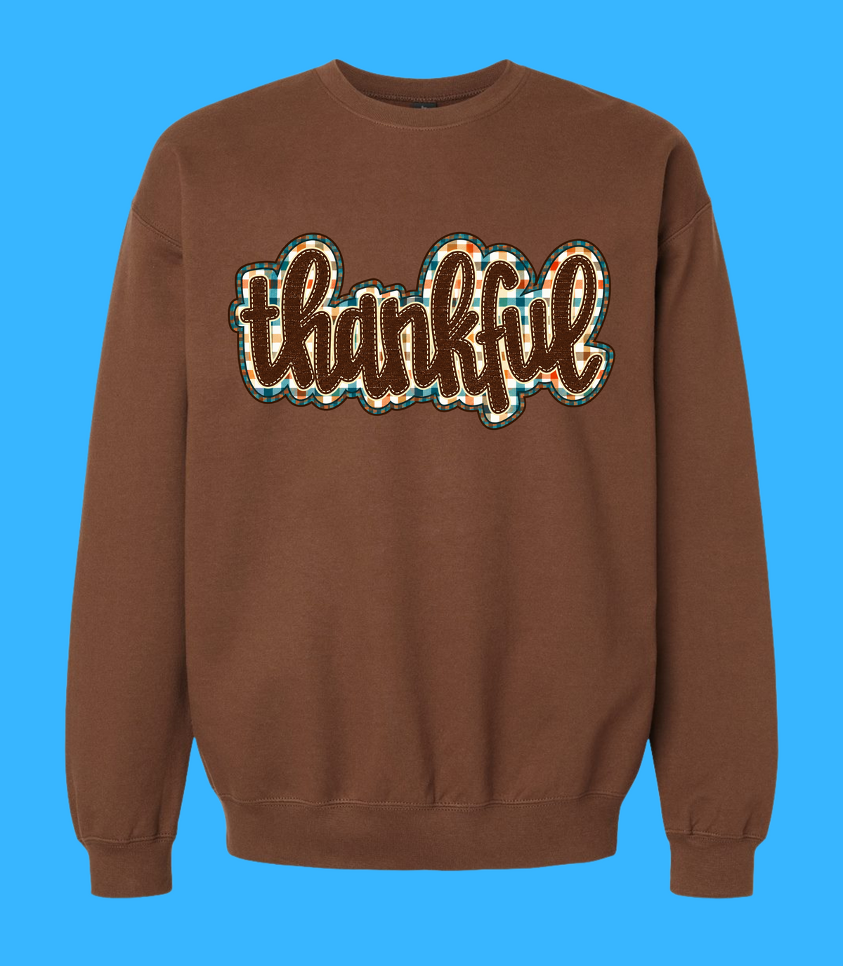 Cocoa crewneck sweatshirt featuring thankful script with cream outlines and colorful plaid accents