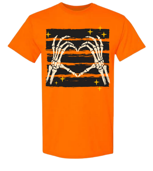 Skeleton Heart Halloween graphic tee in orange with skeleton hands forming a heart on black and orange distressed stripes with gold stars