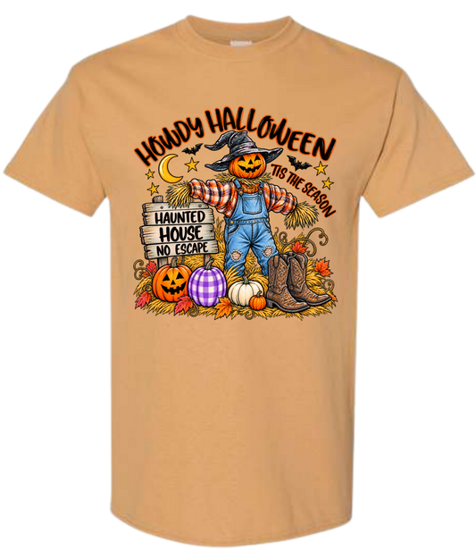 Howdy Halloween Tis The Season graphic tee in golden tan with pumpkin scarecrow, cowboy boots, and jack-o-lanterns